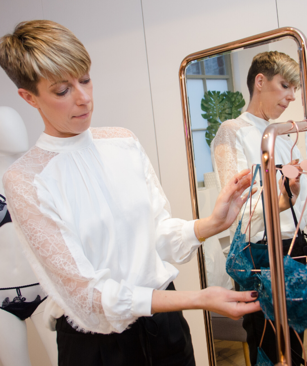 Sarah Connelly looking at lingerie on rose gold hanging rail