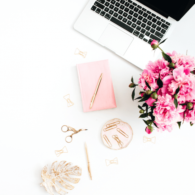 Sarah Connelly Boutique Business Strategy, transforming from scrappy, overwhelmed entrepreneur to mindful business leader. Desk view with notepad, flowers, and laptop.