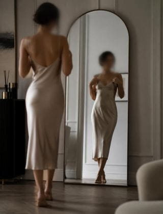 woman in a luxury silk slip admiring her reflection